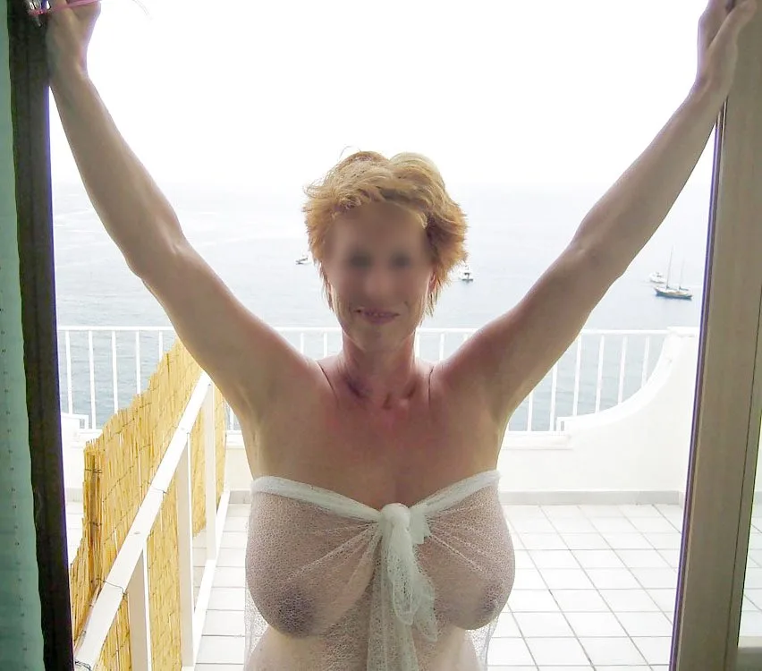 Les gros seins d'une belle cougar nue sur cette photo sont juste à peine cachés par un tissu transparent. On voit qu'elle a des très gros seins qu'elle offre fièrement